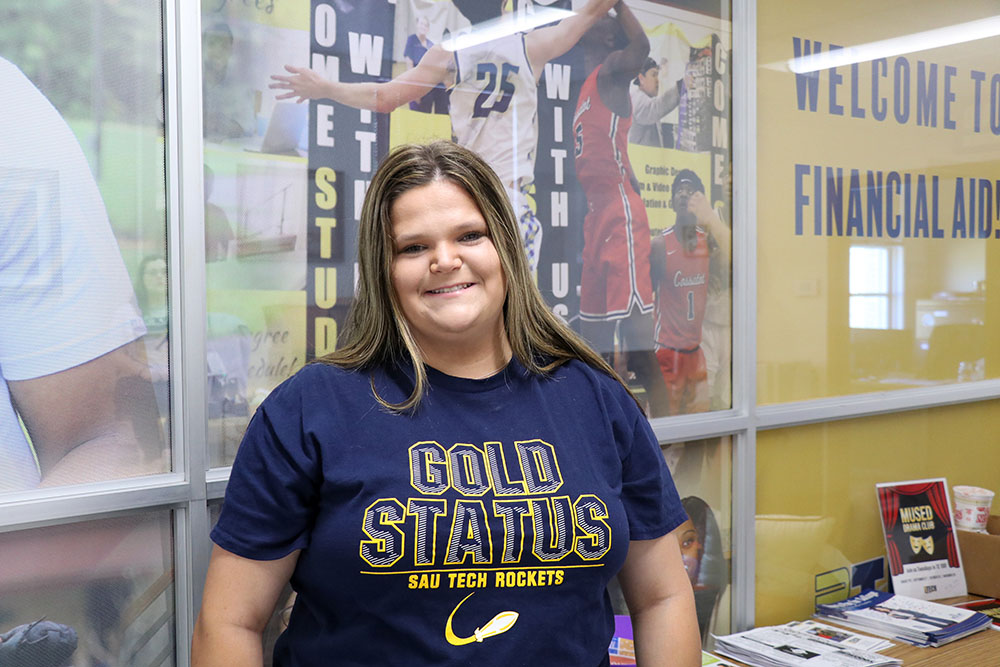 Brunette female in front of Financial Aid office